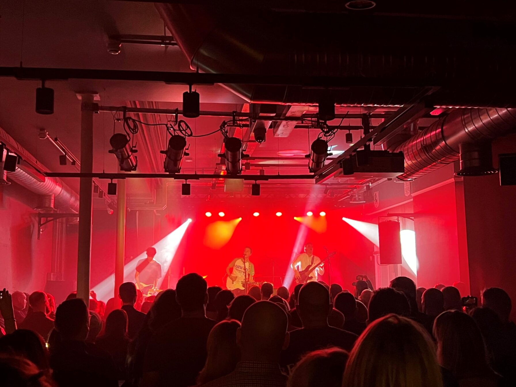 Crowd watching a band play in a crowded venue