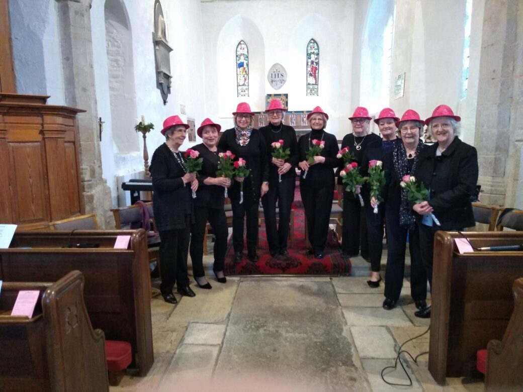 Group of nine women in village church holding flowers